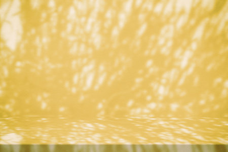 Stucco Table with Grass Shadow on Concrete Wall Texture Background in Fortuna Gold Color Tone, Suitable for Cosmetic Product Presentation Backdrop, Display, and Mock up.の写真素材