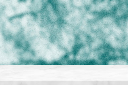 White Marble Table with Tree Shadow on Stucco Wall Texture Background, Suitable for Product Presentation Backdrop, Display, and Mock up.の写真素材