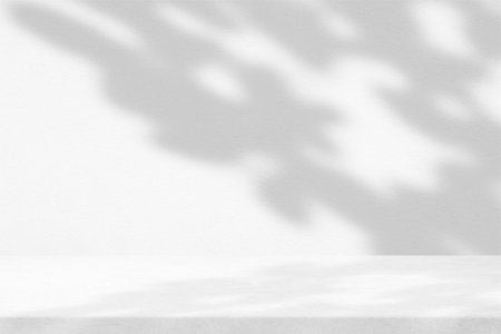 White Wooden Table with Leaf Shadow on Stucco Wall Texture Background, Suitable for Product Presentation Backdrop, Display, and Mock up in Minimal Style.の写真素材