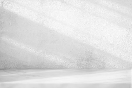 Marble Table with White Stucco Wall Texture Background with Light Beam and Shadow, Suitable for Product Presentation Backdrop, Display, and Mock up.の写真素材
