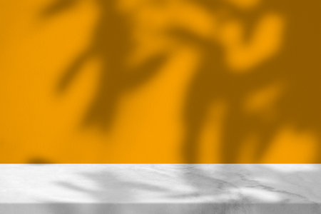 Leaves Shadow on Orange Concrete Wall and Marble Table Background, Suitable for Product Presentation Backdrop, Display, and Mock up.の写真素材