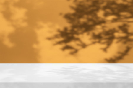 White Stucco Table with Tree Shadow on Concrete Wall Texture Background in Marigold Tone, Suitable for Product Presentation Backdrop, Display, and Mock up.の写真素材
