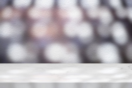 Marble Table with White Stucco Wall Texture Background with Light Beam, Bokeh and Shadow, Suitable for Product Presentation Backdrop, Display, and Mock up.の写真素材