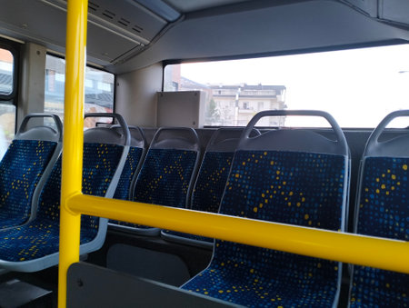 Interior of a bus with blue seats and yellow seats in a row