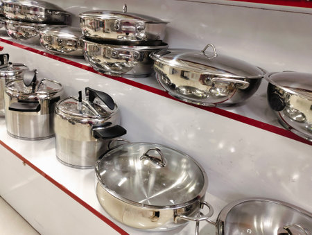 stainless steel pots and pans on shelf in a restaurant.