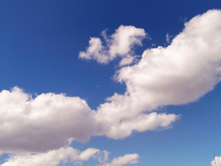 Blue sky background with white clouds. Cumulus white clouds in the blue sky.