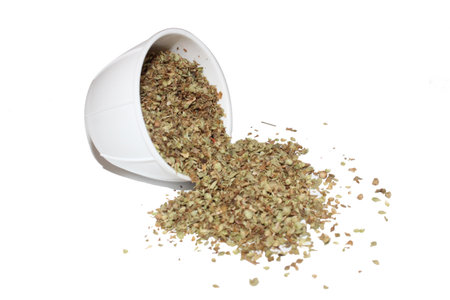 Dried oregano in a white cup on a white backgroundの写真素材