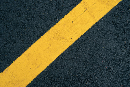A close-up of a yellow lane on an asphalt road.の写真素材