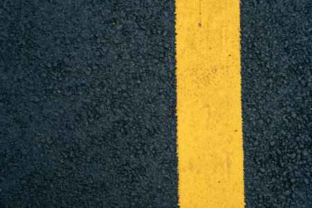 A close-up of a yellow lane on an asphalt road.の写真素材