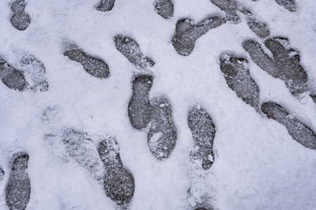 footprints on the snow piled up on the city streets.の写真素材