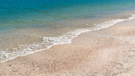 Summer beach sand, blue waves and white foamの写真素材