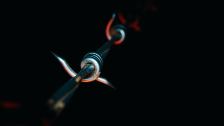 Sharp barbed wire spike detail in darkness, symbolizing danger, conflict, and warning. 3d renderingの写真素材