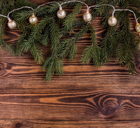 christmas square composition with vintage garland and fir branches on wooden background. string lightsの写真素材