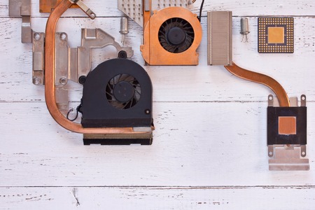 Top view of cooling system of computer processor on white wooden background. Electronic board with...