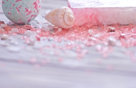 Bath bomb,seashell,handmade soap bar and pink spa salt on wooden background for body care.Soft focus on foreground.の写真素材