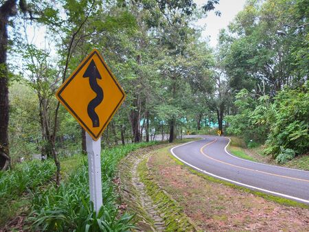 Zigzag warning signs beside a downhill sharp curve in Chiang Mai,Thailand. Horizontal shot.の写真素材