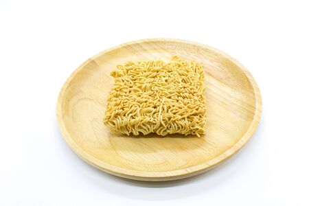 Famous dried instant noodles isolated on a wooden plate with white background. Horizontal shot.の写真素材