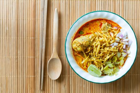 Northern Thai food (Khao Soi), spicy curry noodles soup with coconut milk and chicken on bamboo mat, Top viewの写真素材