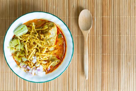 Northern Thai food (Khao Soi), spicy curry noodles soup with coconut milk and chicken on bamboo mat, Top viewの写真素材