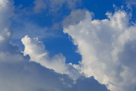 White clouds against the blue sky background in sunny cloudy summer day.の写真素材