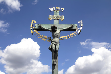 PRAGUE, CZECH REPUBLIC - JULY 30, 2016: 17th Century Crucifixion statue with Hebrew lettering in Charles Bridge in Prague, Czech Republicの写真素材