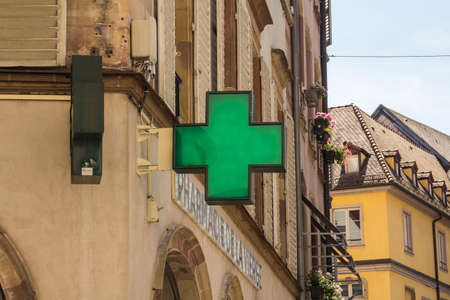 Strasbourg, France : Close up of pharmacy sign / logo. Green cross. Medicine, pharmacy, health business.のeditorial素材