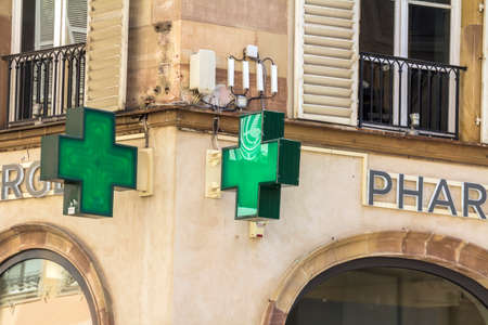 Strasbourg, France : Close up of pharmacy sign / logo. Green cross. Medicine, pharmacy, health business.のeditorial素材
