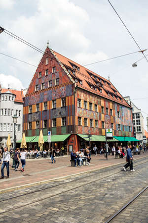 Augsburg, Germany - May  2019: Old town with Weberhaus house and red tram in Augsburg. Augsburg is...