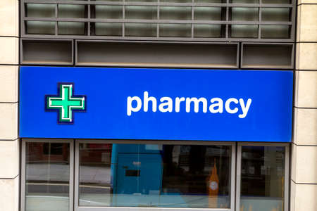 London, England : Pharmacy store entrance and sign pharmacy in downtown city during daytimeのeditorial素材