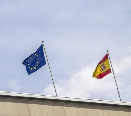 Spanish and European flags waving against of sky