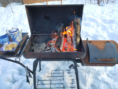 Barbeque fire with a cup of tea and some sweetsの写真素材