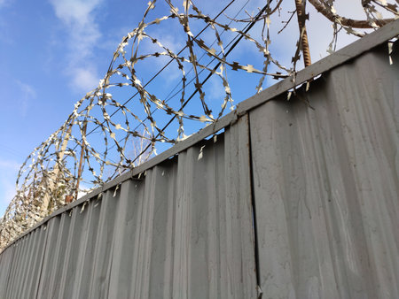 Barbed wire protection against thieves on a fenceの写真素材