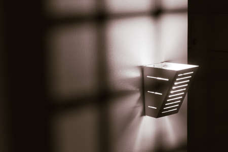 A monochromatic picture of a tungsten light on a textured wallの写真素材
