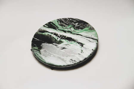 Close-up view of green, white and black epoxy resin marbles in circular pieceの写真素材