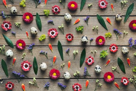Easter arrangement with eggs and flowers on wooden planks. View from above. Flat lay.の写真素材