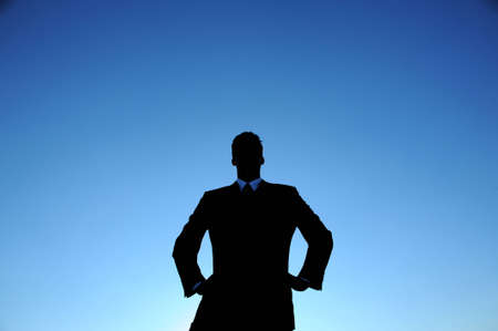 Businessman silhouette against a blue skyの写真素材
