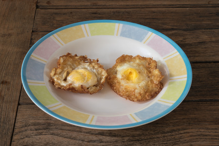 Crispy fried egg on a wooden tableの写真素材