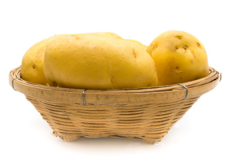 whole potatoes in the basket on white backgroundの写真素材