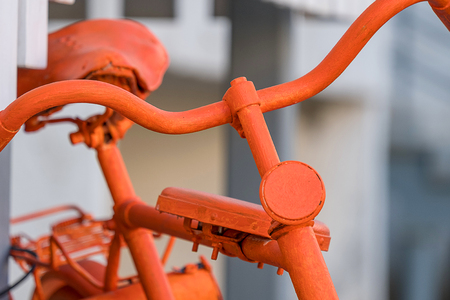 the front part of an old Bicycle is painted in the orange colour, the reflector and the wheelの写真素材