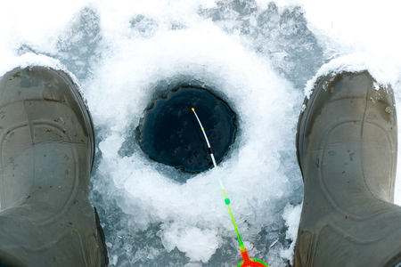 tackles for winter fishing and boots for winter fishing, a fisherman is waiting for bitesの写真素材