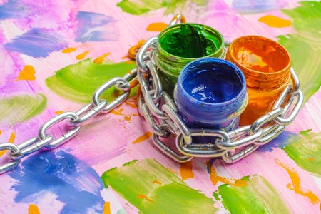 chain metal and cans with paint for children's creativity, colorful background paintedの写真素材