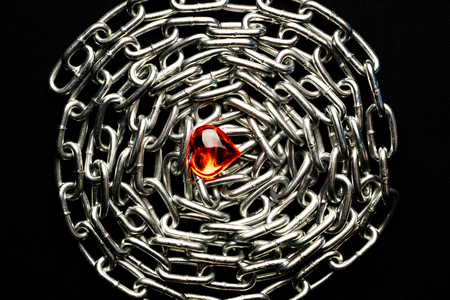 chain of metal lined on a black background around in the center of a glass heart of love and metal