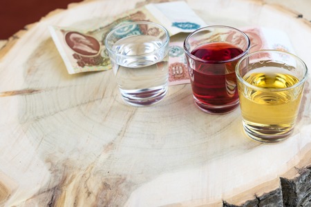 three glasses and old money of the USSR on the tree stump, stylistics under the wild natureの写真素材