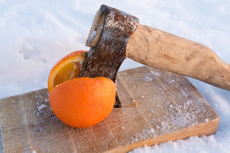 On the board is an orange that was cut with an axe in the winterの写真素材
