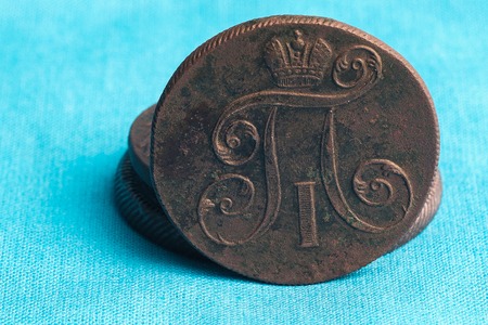 On a blue cloth background there is an old Russian coin of the 17th centuryの写真素材