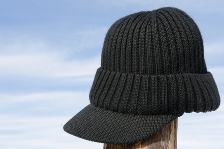 winter knitted hat with a peak against the blue sky, in winter