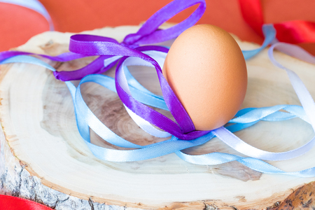 colorful ribbon gift and egg on a wooden background, bow of ribbonsの写真素材
