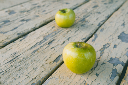 two green apples on old scraped boards, two fruits and old wooden boardsの写真素材