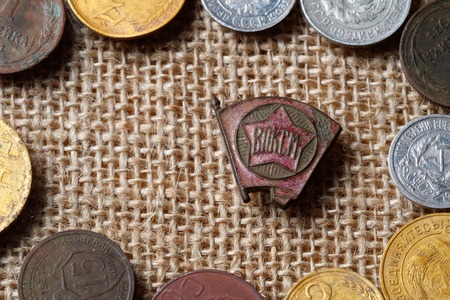 Times of the USSR icon of the Komsomol surrounded by Soviet coins, tissue backgroundの写真素材