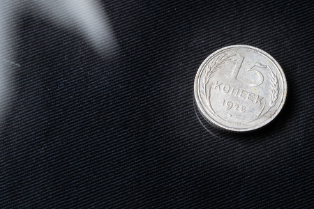 15 kopecks in 1925 on a glass with a black cloth lining, a reflection of a coin on the glass and a glareの写真素材